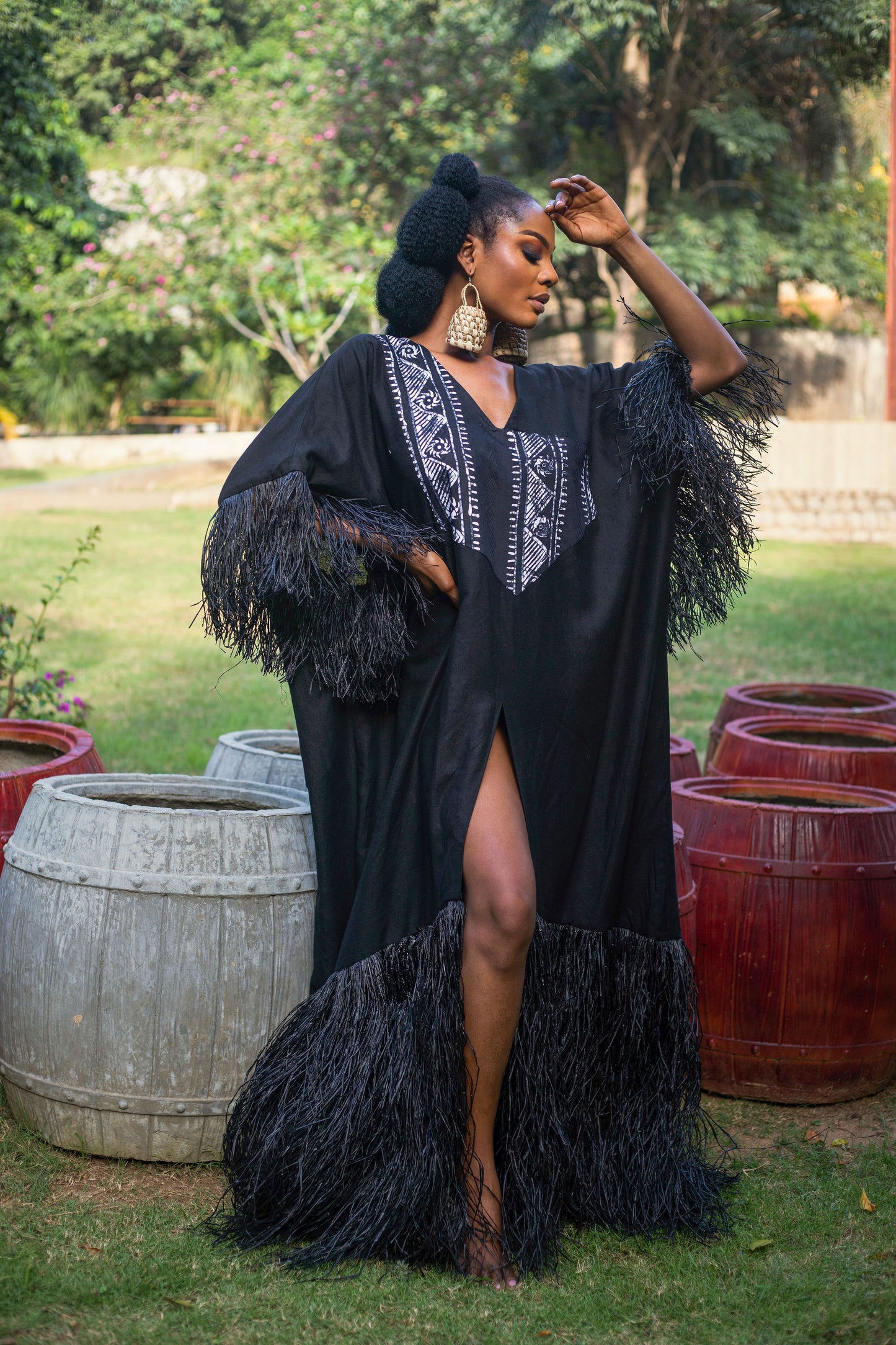 The Azi Maxi Dress is long maxi dress with raffia hem and sleeves, complemented by a high front slit. Also featuring a flowing silhouette that gracefully drapes to the ground. The incorporation of raffia adds a unique, textured contrast at the hem and sleeves, giving the dress an earthy, boho touch Crafted from lightweight linen fabric ideal for warm weather or Summer. It offers a distinctive blend of elegance and bohemian flair. Can be styled with a sandals or wedges heel