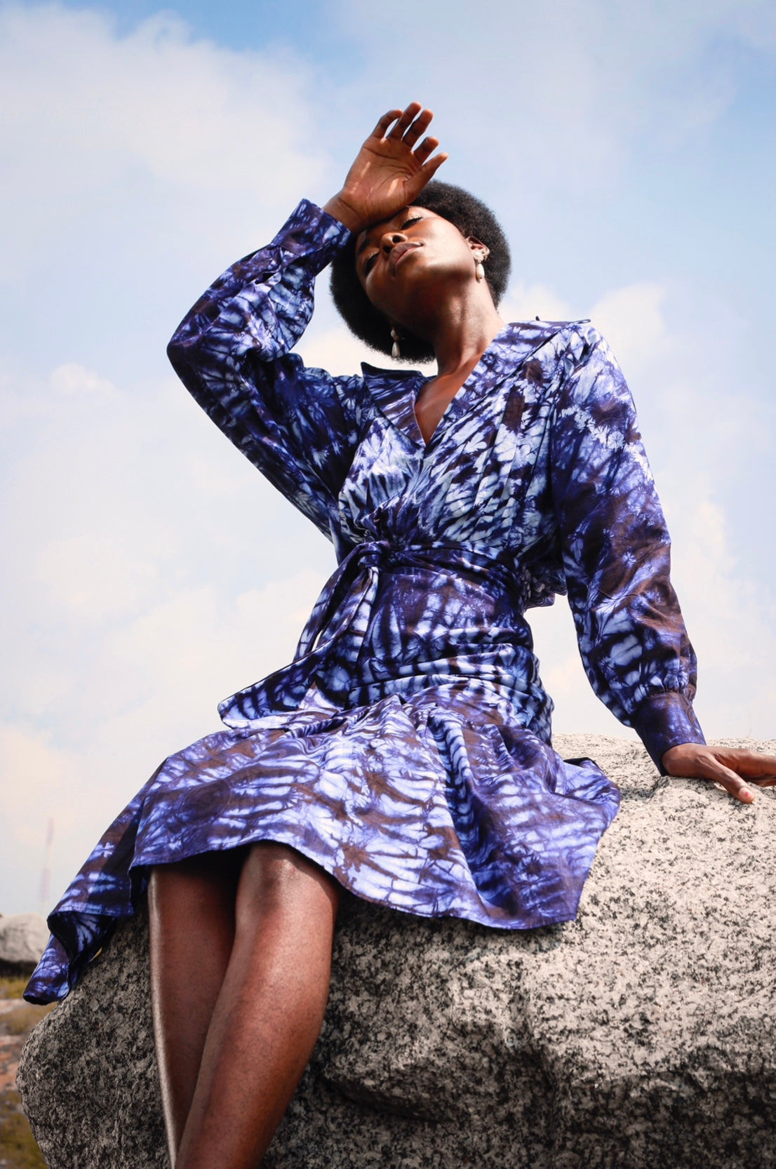 Elevate your style with the Ijeoma Dress. Made from hand-dyed cotton adire fabric by female artisans which means that each clothe comes with it's design, this dress features a unique dark blue and white design that will turn heads. With long sleeves, a lapel collar, and gathers above the knee, it's both fashionable and comfortable. Feel confident and make a statement in this one-of-a-kind dress!
